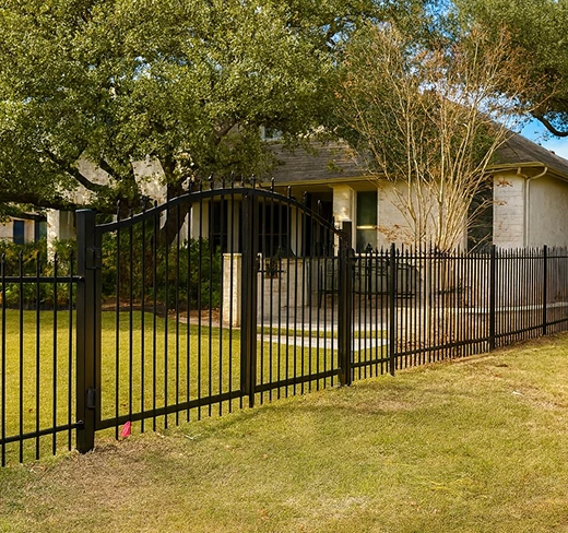 Ornamental fence with arched gate on residential property in Austin.